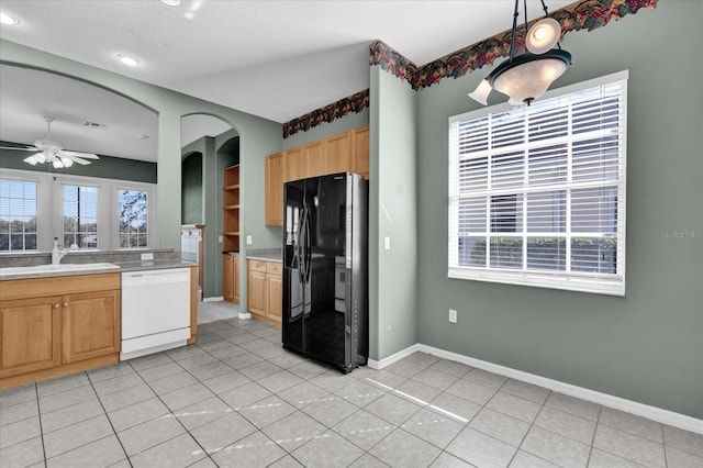 kitchen with black fridge, white dishwasher, sink, light tile patterned floors, and hanging light fixtures