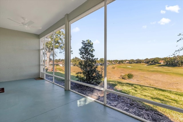 unfurnished sunroom with ceiling fan