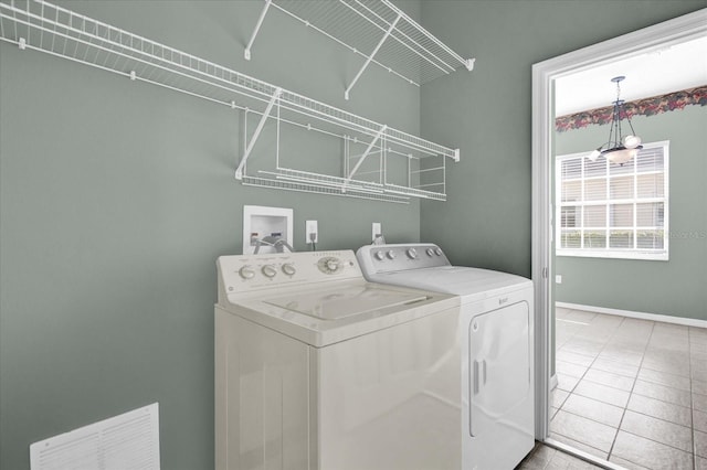 laundry area featuring light tile patterned flooring and washing machine and dryer