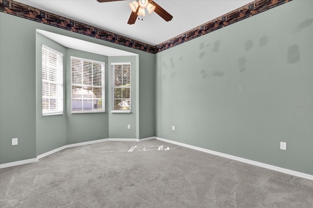 empty room featuring ceiling fan and light colored carpet