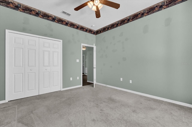 unfurnished bedroom featuring ceiling fan, a closet, and carpet