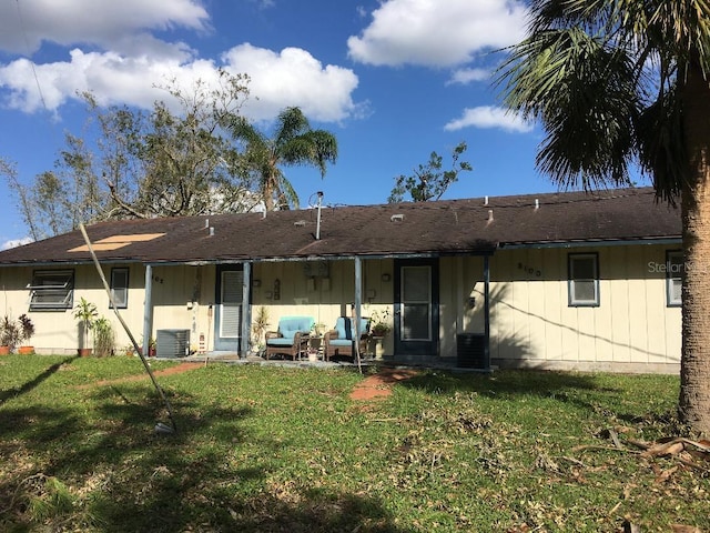 rear view of house with outdoor lounge area, a yard, and central air condition unit