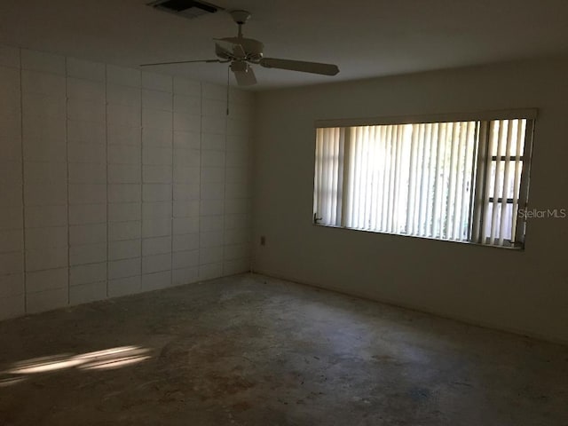 empty room featuring ceiling fan and concrete flooring