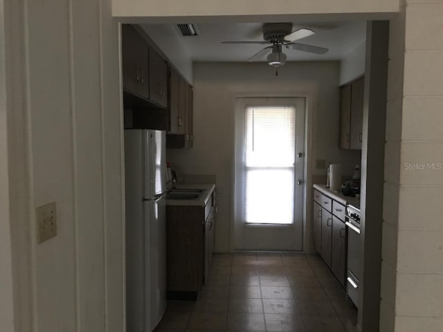 5100 Rilma Ave, Sarasota, FL 34234 - kitchen with freestanding refrigerator, light countertops, ceiling fan, and light tile patterned floors