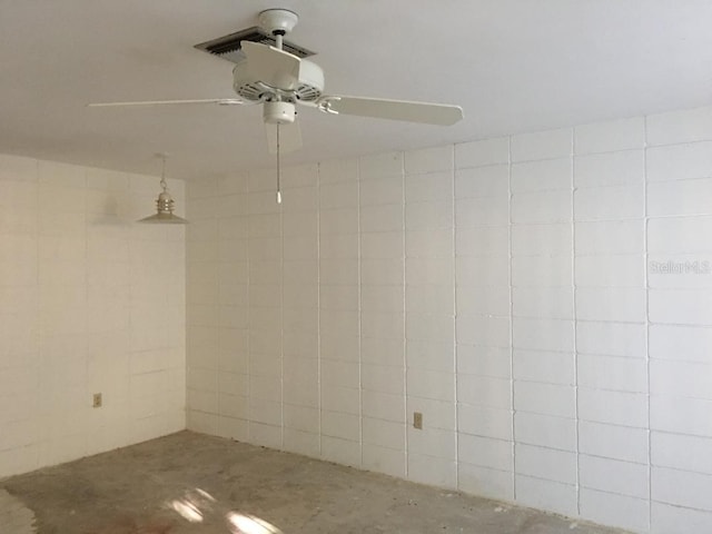 interior space featuring ceiling fan and concrete flooring