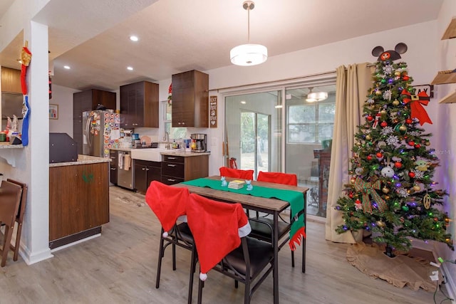 dining space with light hardwood / wood-style floors and sink