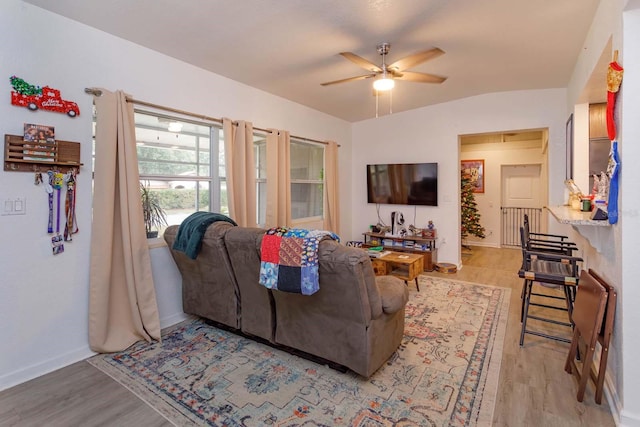 living room with light wood-type flooring, vaulted ceiling, and ceiling fan