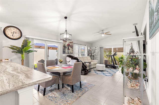 dining room with ceiling fan with notable chandelier and vaulted ceiling