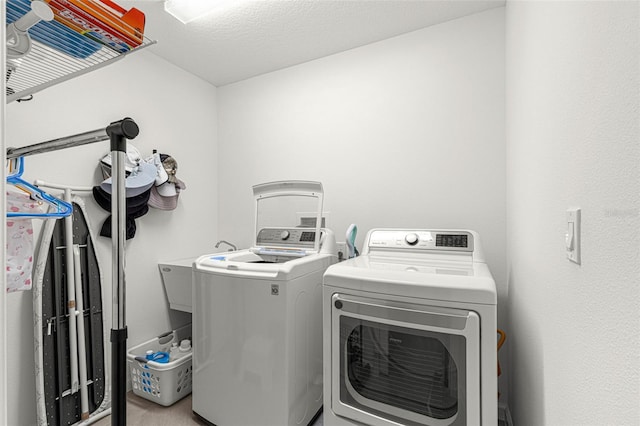 laundry room with separate washer and dryer and a textured ceiling