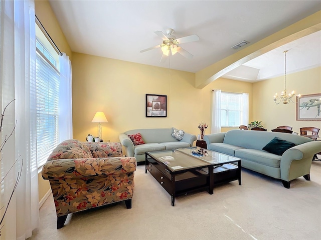 living room with ceiling fan with notable chandelier and light carpet