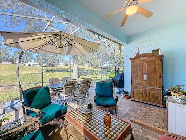 view of patio / terrace featuring ceiling fan and glass enclosure