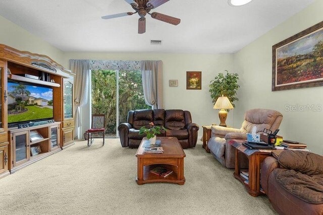 carpeted living room with ceiling fan