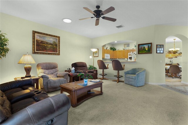 living room with light colored carpet and ceiling fan with notable chandelier