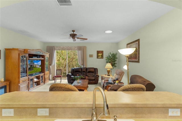 carpeted living room with ceiling fan