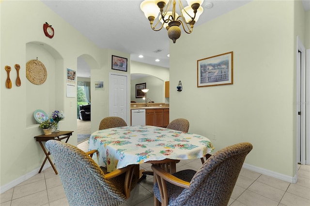 dining area with light tile patterned floors, an inviting chandelier, and sink