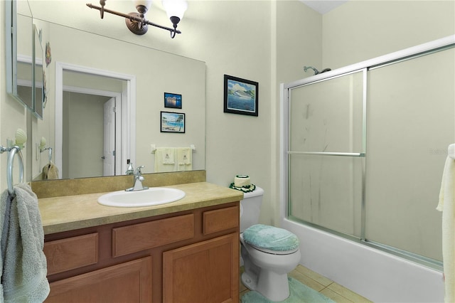 full bathroom featuring tile patterned flooring, vanity, toilet, and shower / bath combination with glass door