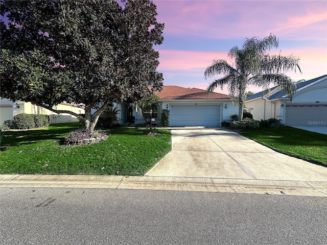 view of front of property with a garage and a yard