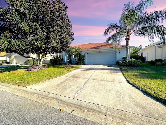 view of front of home with a lawn and a garage