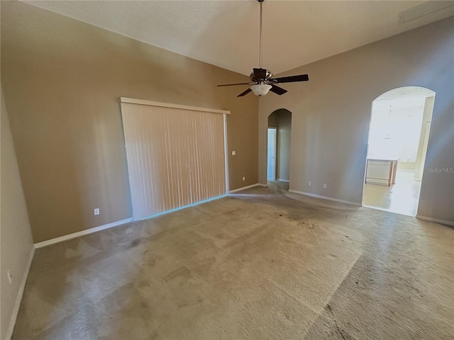 carpeted spare room featuring ceiling fan, lofted ceiling, and a textured ceiling