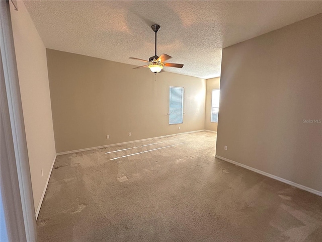 spare room featuring carpet flooring, ceiling fan, and a textured ceiling