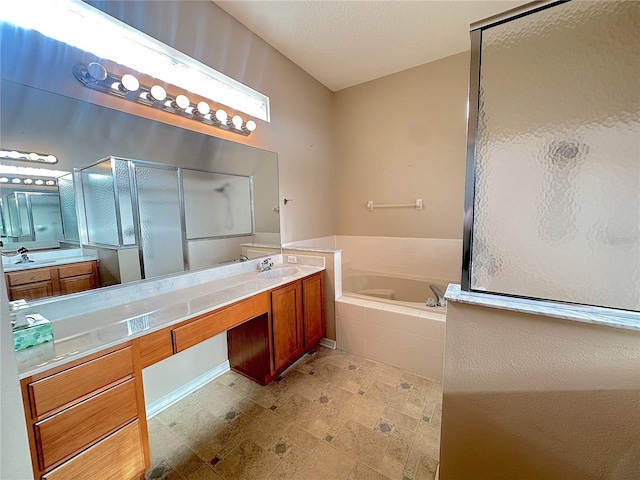 bathroom featuring plus walk in shower, vanity, and a textured ceiling