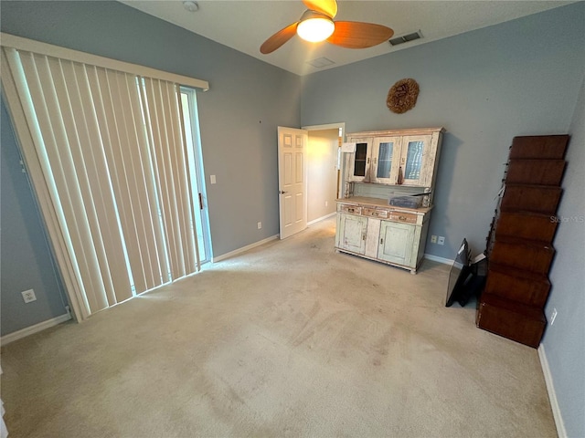 unfurnished living room featuring ceiling fan and light colored carpet