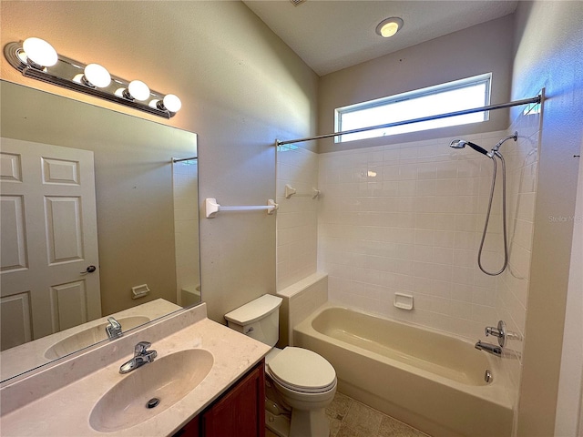 full bathroom featuring vanity, tiled shower / bath combo, and toilet