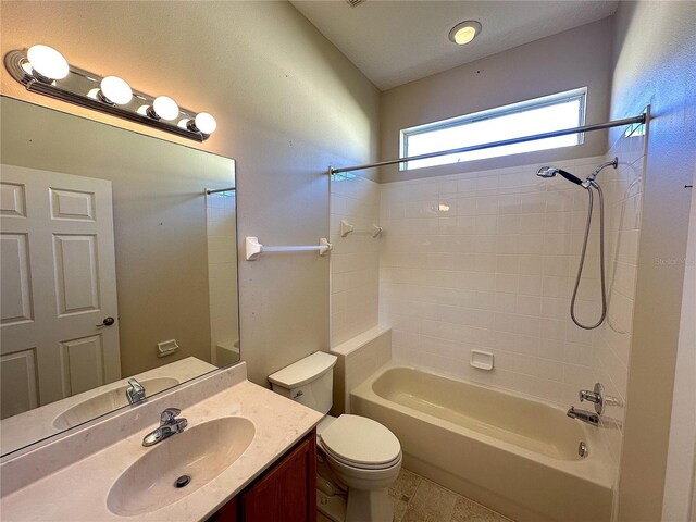 full bathroom featuring vanity, tiled shower / bath combo, and toilet