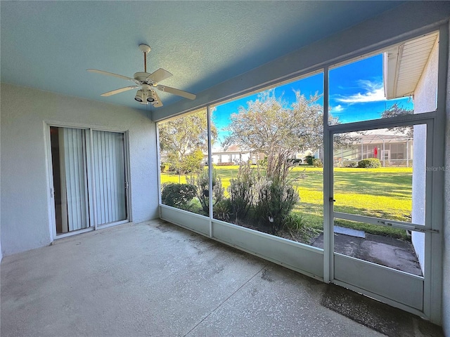 unfurnished sunroom with ceiling fan