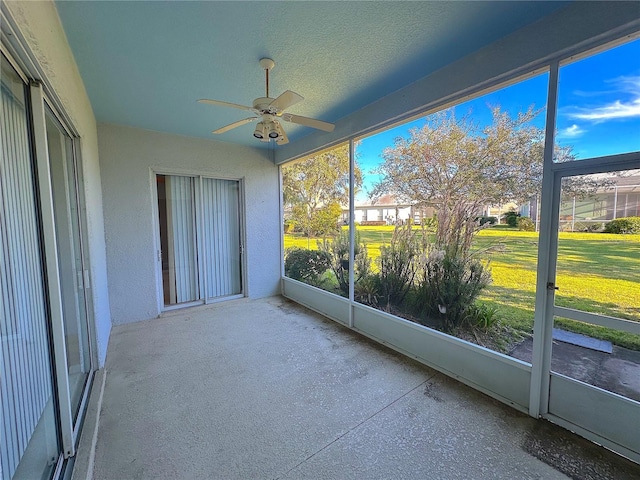 unfurnished sunroom with ceiling fan