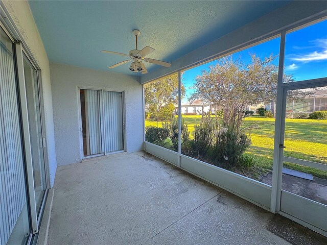 unfurnished sunroom with ceiling fan