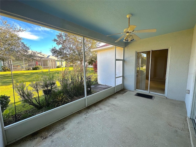 unfurnished sunroom featuring ceiling fan