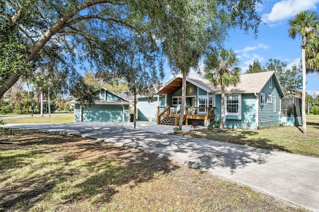 ranch-style home with a porch, a garage, an outbuilding, and a front yard