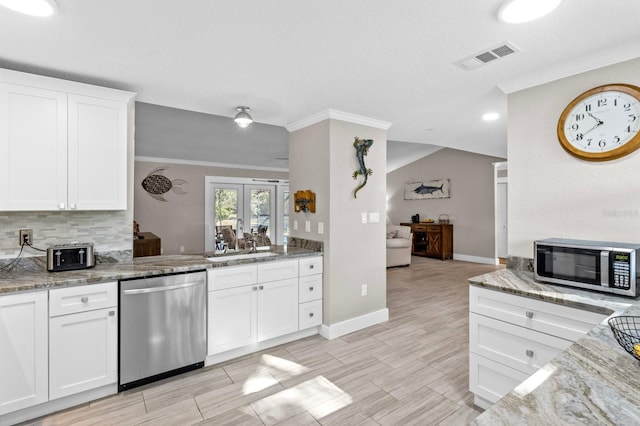 kitchen featuring white cabinets, appliances with stainless steel finishes, stone counters, and sink