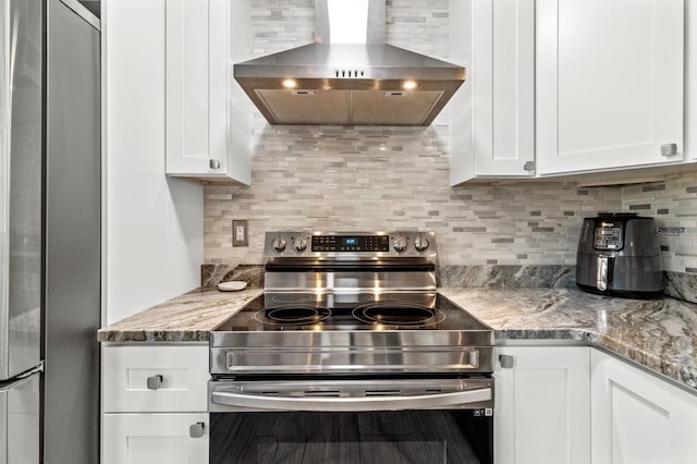 kitchen with white cabinets, stainless steel appliances, and wall chimney range hood