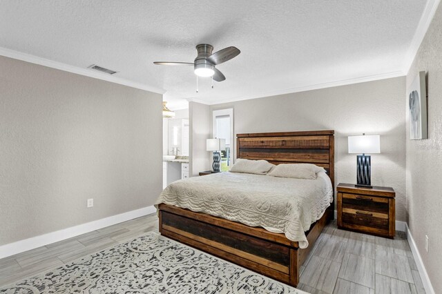 bedroom with ornamental molding, a textured ceiling, ceiling fan, light hardwood / wood-style flooring, and connected bathroom