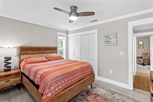 bedroom featuring ceiling fan, a closet, and crown molding