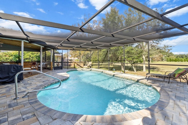 view of pool with glass enclosure and a patio