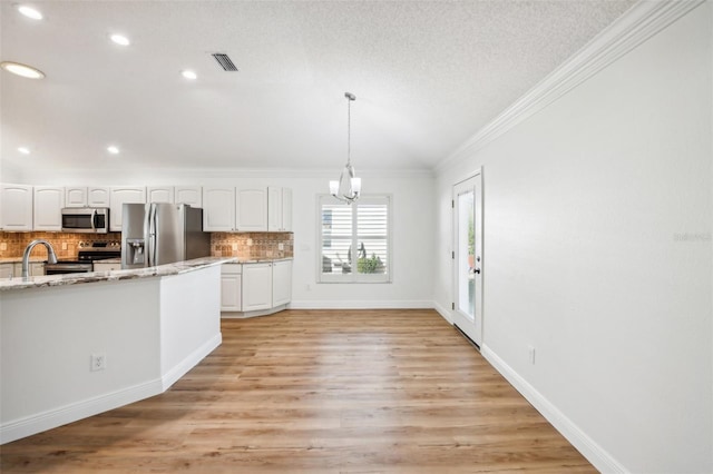 kitchen with light stone counters, white cabinets, light hardwood / wood-style floors, and appliances with stainless steel finishes