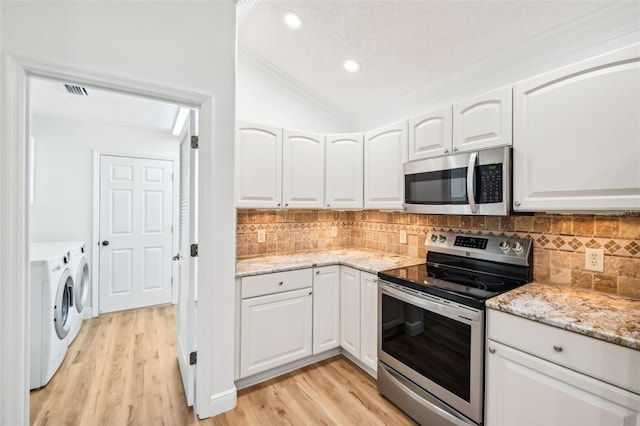 kitchen featuring washer and dryer, appliances with stainless steel finishes, a textured ceiling, and white cabinets