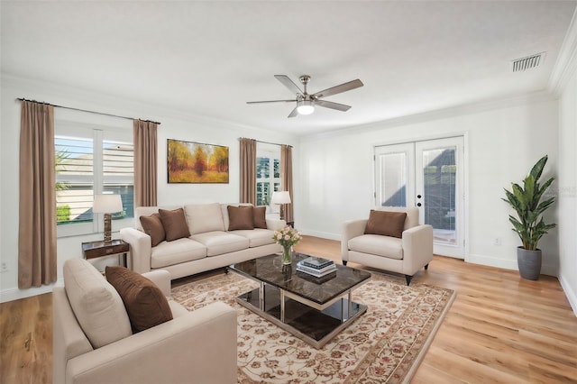 living room featuring ceiling fan, light hardwood / wood-style floors, crown molding, and french doors