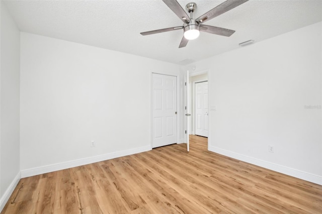 empty room featuring ceiling fan, a textured ceiling, and light hardwood / wood-style flooring