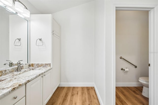 bathroom featuring hardwood / wood-style floors, vanity, and toilet