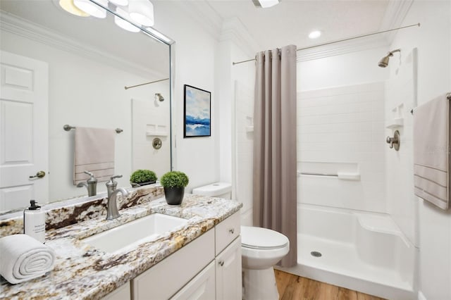 bathroom with vanity, a shower with curtain, crown molding, hardwood / wood-style flooring, and toilet