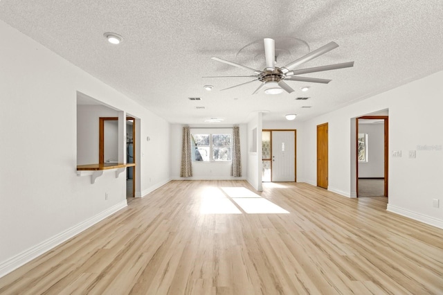 unfurnished living room with ceiling fan, a textured ceiling, and light wood-type flooring