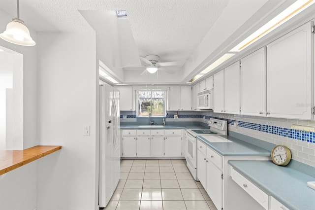 kitchen featuring white cabinetry, sink, decorative light fixtures, and white appliances