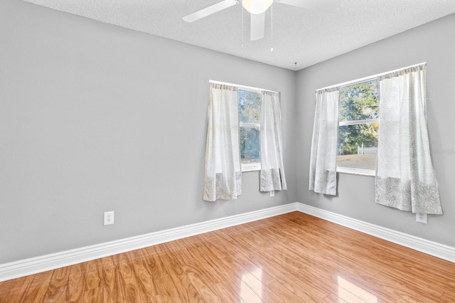 spare room featuring ceiling fan, wood-type flooring, and a textured ceiling