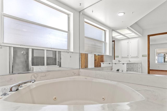 bathroom featuring vanity, a tub, and a wealth of natural light