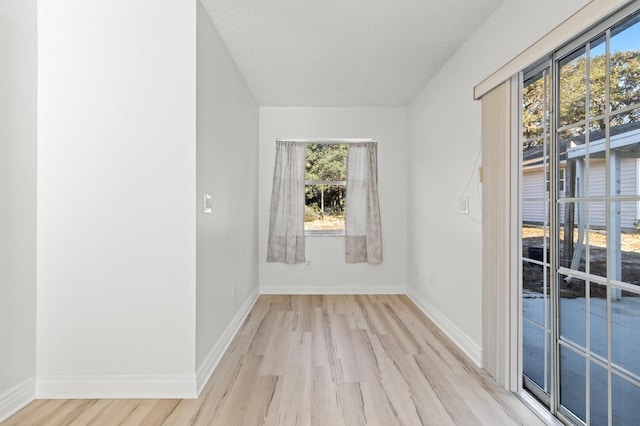 spare room with light hardwood / wood-style floors and a textured ceiling