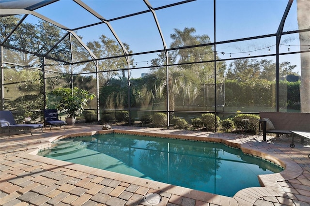 view of swimming pool with a patio area and glass enclosure